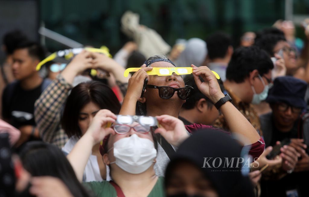 Warga mengamati fenomena gerhana matahari parsial di Plaza teater Kecil Taman Ismail Marzuki, Jakarta, Kamis (20/4/2023). Masyarakat menyaksikan gerhana Matahari parsial tersebut, baik dengan bantuan teleskop maupun kacamata gerhana. 