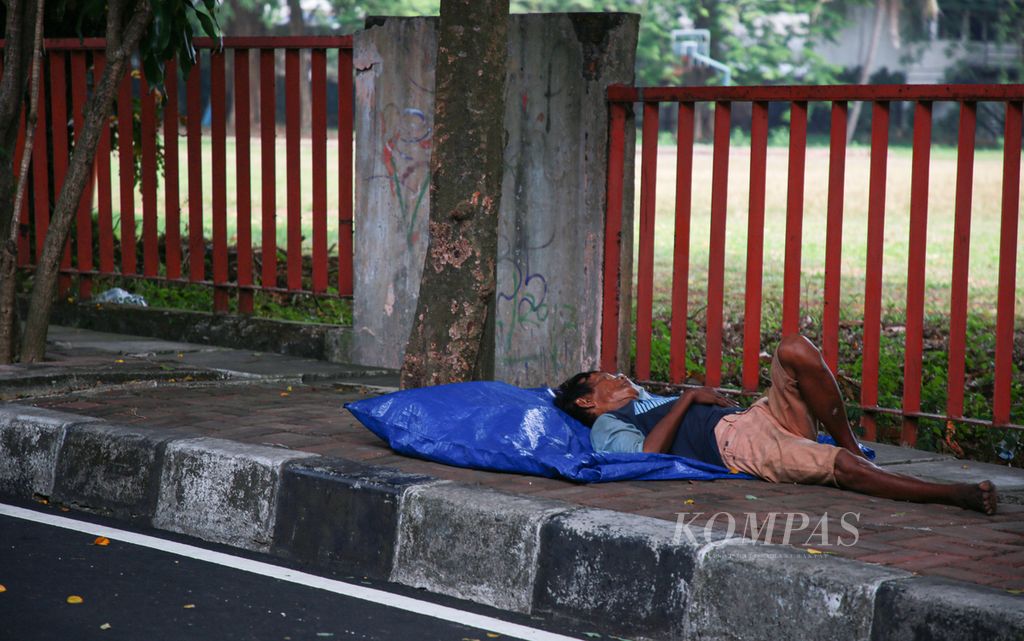A garbage collector was found asleep on the side of the road in the Menteng area of Central Jakarta on Wednesday (31/8/2022). The lower-middle-income group is the most affected by oil fuel policies.