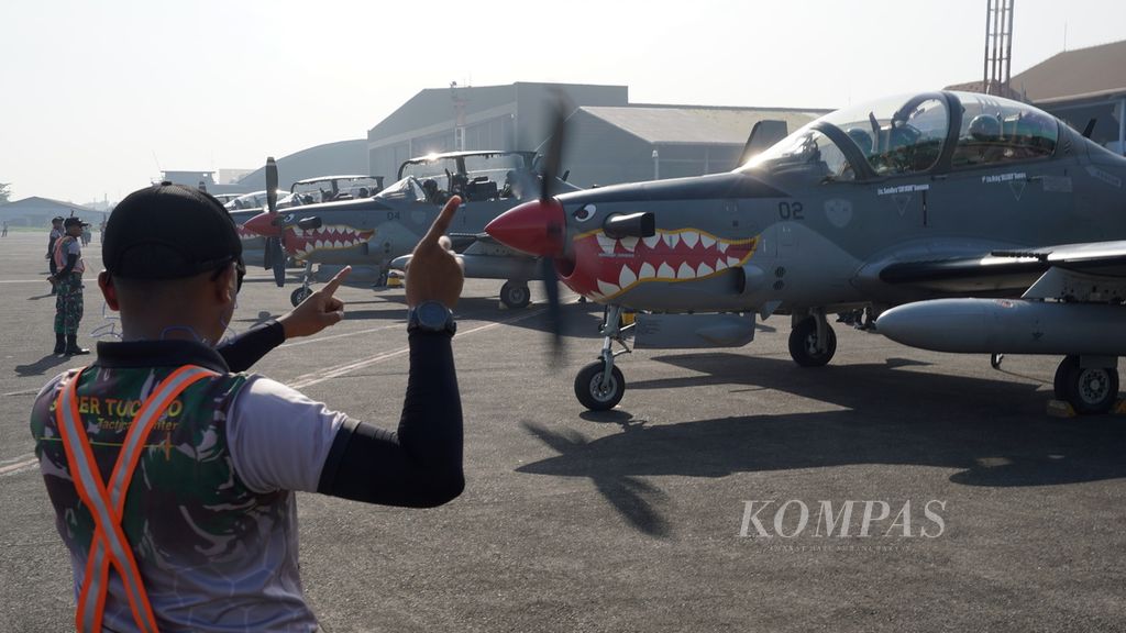 Marshaller mengarahkan penerbang EMB-314 Super Tucano bersiap menuju landasan dalam gladi kotor Hari Ulang Tahun Ke-77 TNI Angkatan Udara di Lapangan Udara Halim Perdanakusuma, Jakarta Timur, Rabu (5/4/2023). 