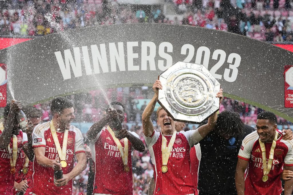 Kapten Arsenal, Martin Odegaard, mengangkat trofi Community Shield saat bersama-rekannya merayakan sukses Arsenal mengalahkan Manchester City lewat adu penalti di Stadion Wembley, London, Inggris, 6 Agustus 2023. 