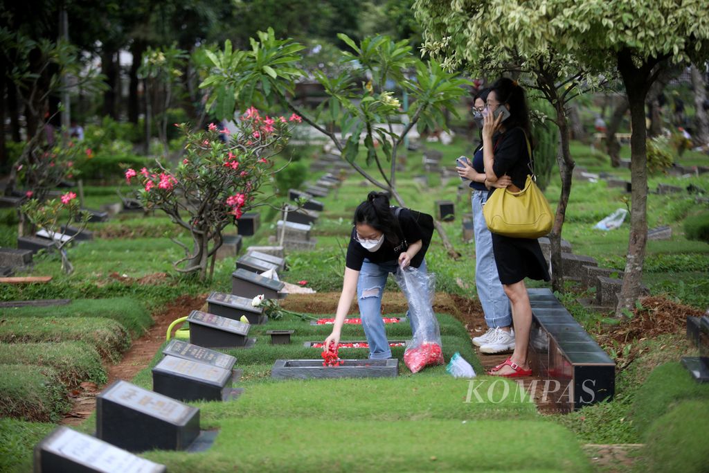 Peziarah menaburkan bunga di pusara keluarganya di TPU Karet Bivak, Karet Tengsin, Tanah Abang, Jakarta Pusat, Kamis (24/3/2022). 