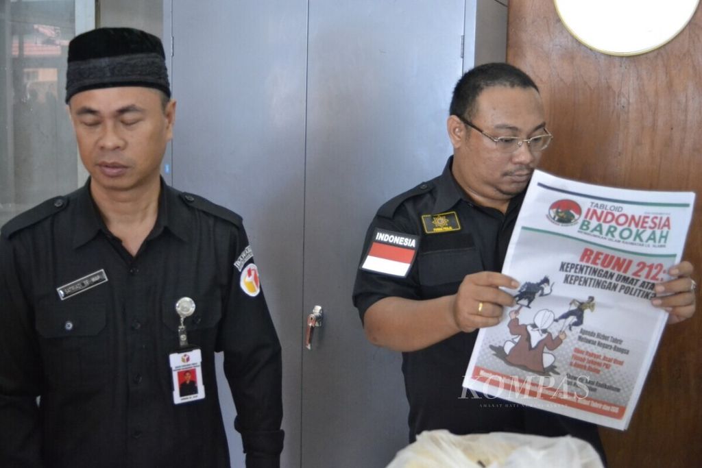 Ketua Bawaslu Prvonsi Kalteng Satriadi (kiri) bersama staf yang membaca tabloid <i>Indonesia Barokah</i> di Palangkaraya, Kalteng. Tabloid itu disita petugas.