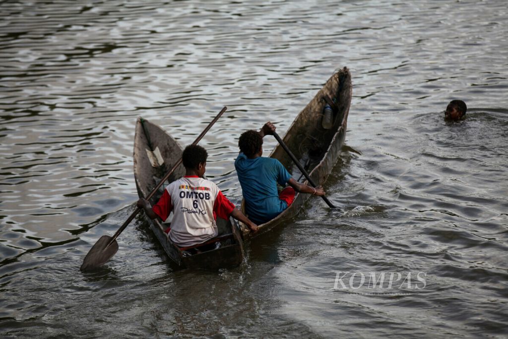 Warga bermain perahu menyusuri Sungai Otakwa, Distrik Mimika Timur Jauh, Kabupaten Mimika, Papua.