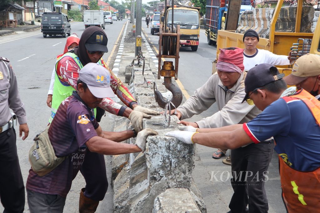 Petugas menutup penggalan jalan atau U-turn dengan pembatas beton menjelang Pasar Tegalgubug, Kabupaten Cirebon, Jawa Barat, Senin (18/4/2022). Pemasangan pembatas tersebut untuk mencegah kemacetan di sekitar pasar saat arus mudik Lebaran 2022.