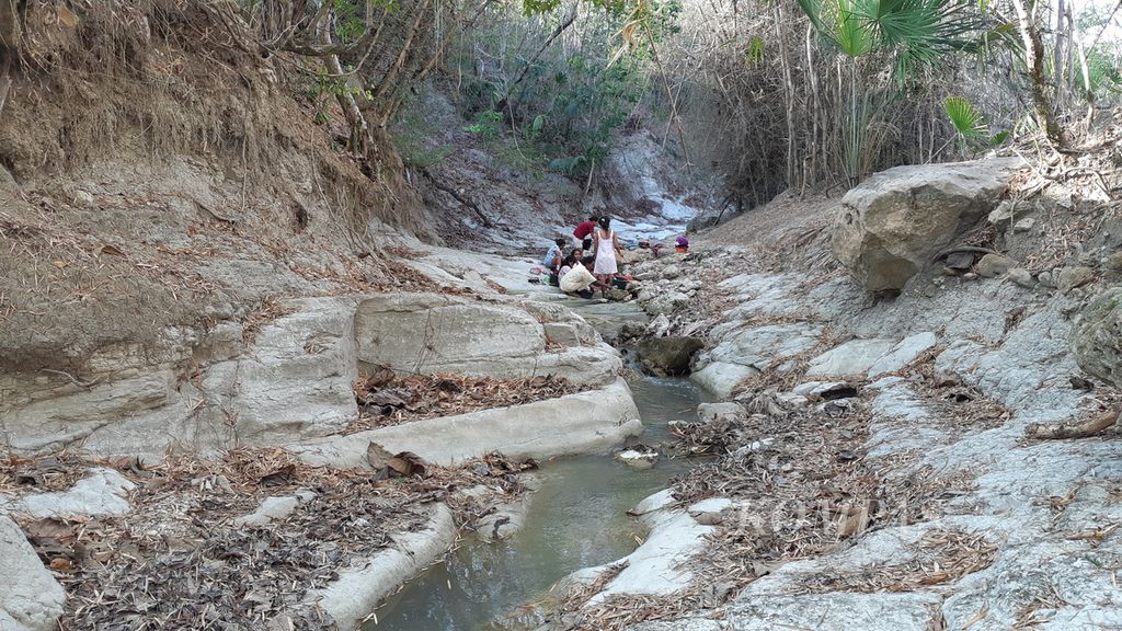 Sejumlah warga di Desa Manulea, Kecamatan Sasitamean, Kabupaten Malaka, NTT, menggunakan air keruh di Kali Babeko untuk mandi dan cuci, seperti tampak pada Rabu (21/10/2020). Daerah itu mengalami krisis air bersih sejak lama.
