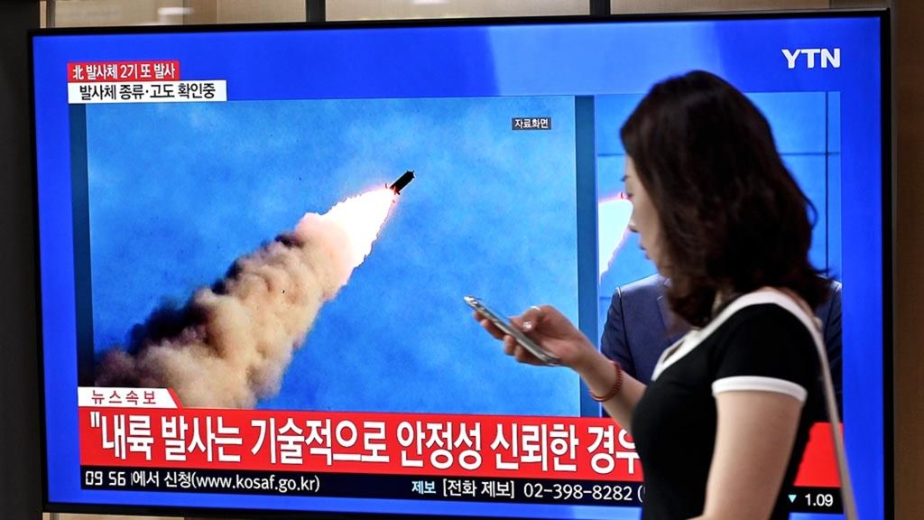 Seorang warga berjalan melewati layar televisi di sebuah stasiun kereta api di Seoul, Selasa (10/9/2019), yang menyiarkan peluncuran rudal Korea Utara. Korea Utara, Selasa, kembali menembakkan proyektil ke arah laut. Hal itu dikatakan pihak militer Korea Selatan beberapa jam setelah Pyongyang mengatakan bersedia mengadakan pembicaraan dengan Amerika Serikat pada akhir September.