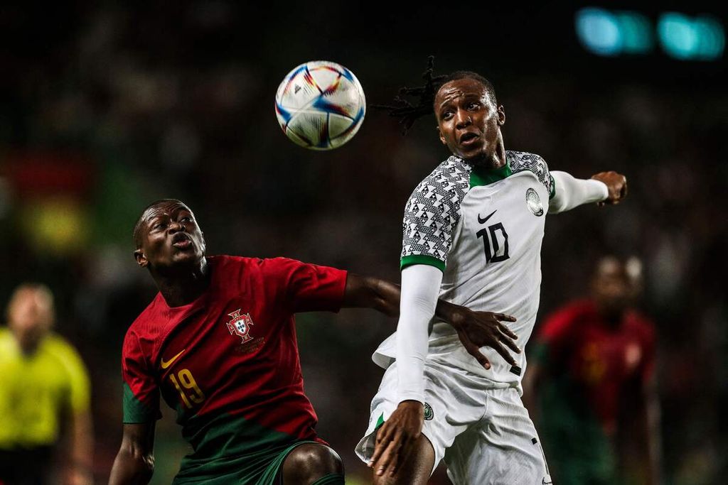 Bek Portugal Nuno Mendes (kiri) berebut bola dengan gelandang Nigeria Joe Aribo dalam pertandingan persahabatan antara Portugal dan Nigeria di Stadio Alvalade, Lisabon, Portugal, Jumat (18/11/2022) dini hari WIB. Portugal mengalahkan Nigeria, 4-0, meskipun tanpa Cristiano Ronaldo. 