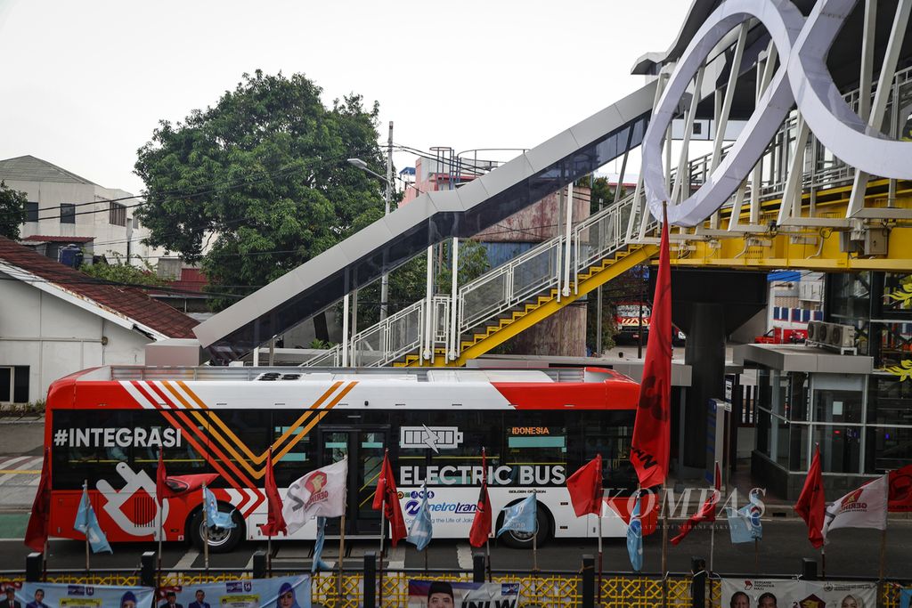 Bus listrik Transjakarta berhenti di halte yang terhubung dengan jembatan penyeberangan orang (JPO) Soepomo di kawasan Tebet, Jakarta Selatan, Senin (15/1/2024). 