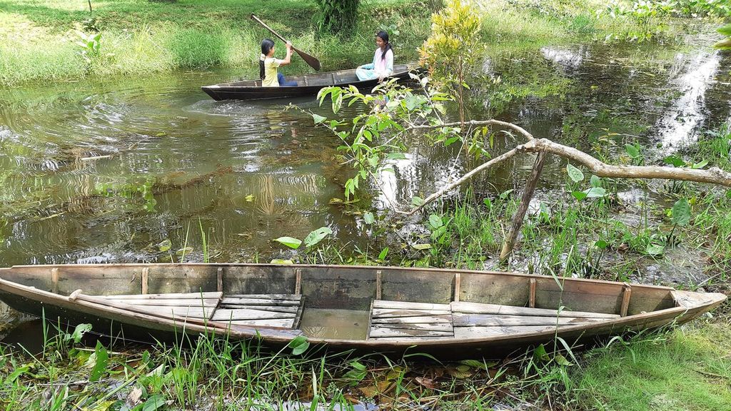 Pengunjung menyusuri sungai menggunakan perahu di Taman Sakat Lebung Panjang, Desa Jambi Tulo, Kecamatan Maro Sebo, Kabupaten Muaro Jambi, Minggu (30/4/2023). 