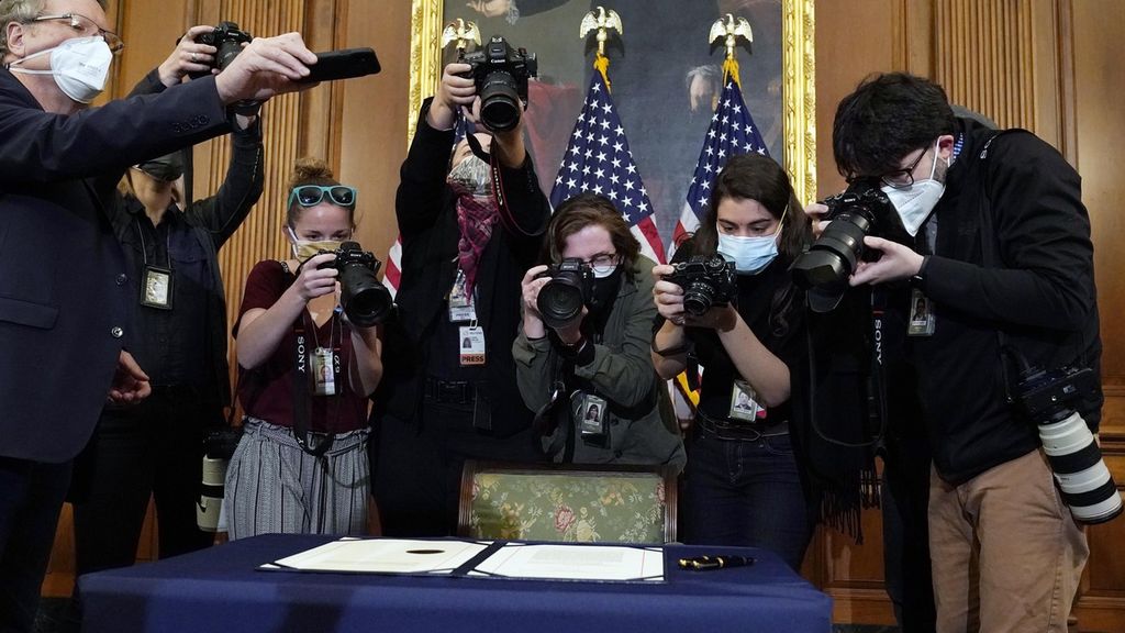 Para jurnalis mengabadikan dokumen pemakzulan terhadap Presiden Donald Trump yang baru saja ditandatangani oleh Ketua Kongres AS Nancy Pelosi di Gedung Capitol Washington, Rabu (13/1/2021).