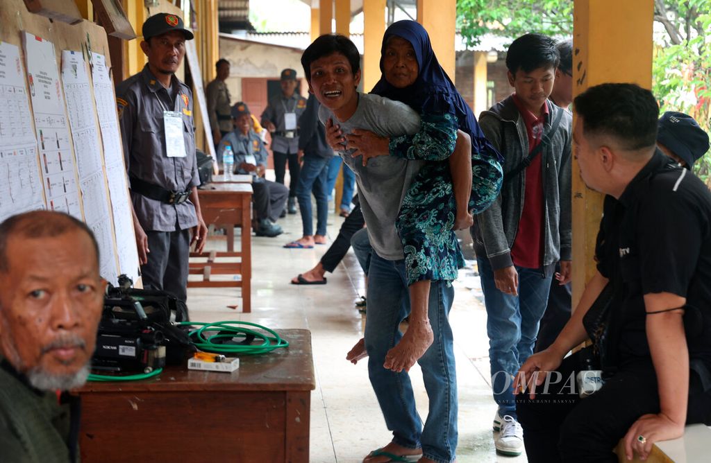 Warga menggendong orangtuanya ke tempat pemungutan suara setelah ditunda karena bencana banjir di SD Negeri Wonorejo 1, Kecamatan Karanganyar, Kabupaten Demak, Jawa Tengah, Sabtu (24/2/2024). 
