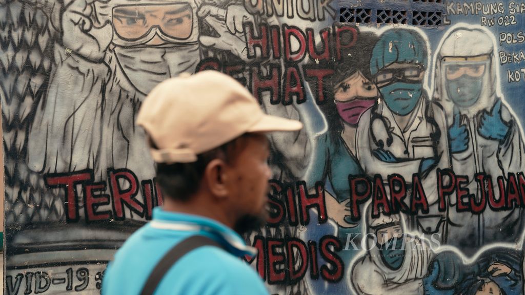 Warga melintasi mural ucapan terima kasih kepada tenaga kesehatan di Kota Bekasi, Jawa Barat, Kamis (1/9/2022). Secara hitungan kasar sesuai standar WHO, yaitu satu dokter untuk 1.000 penduduk, Indonesia masih berada di urutan terbawah di Asia Tenggara menurut laporan WHO tahun 2018.
