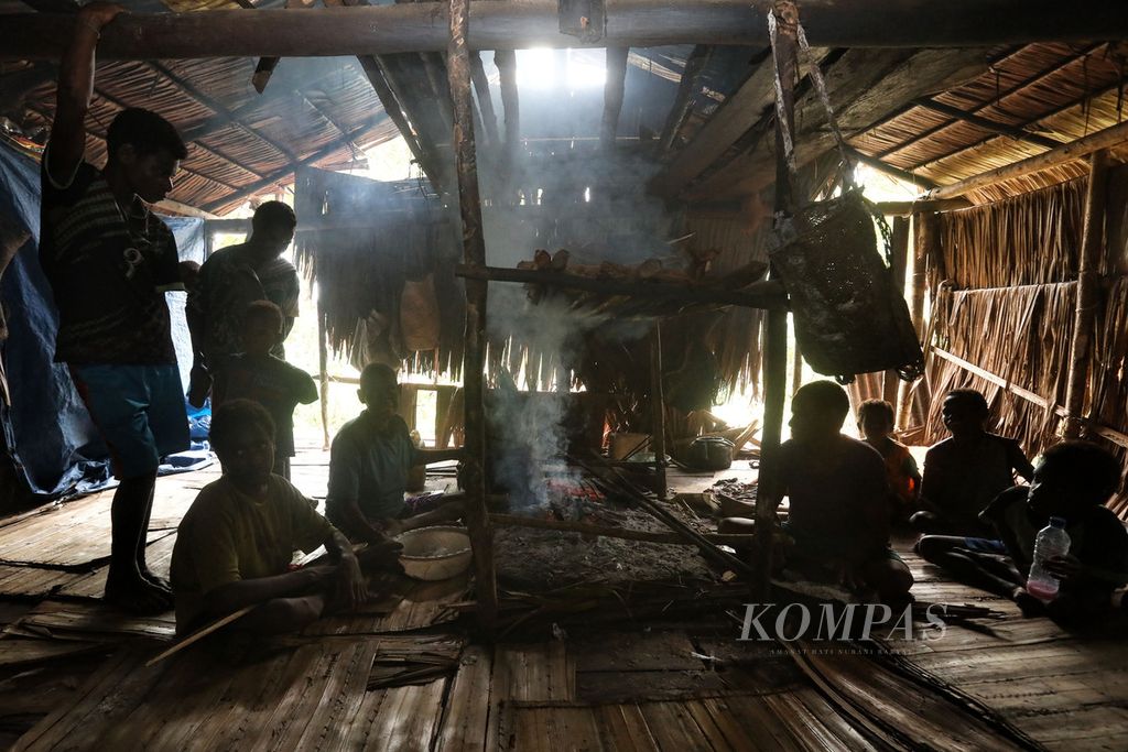 Sebuah keluarga warga Kampung As, Distrik Pulau Tiga, Asmat, Papua, berkumpul di dapur untuk mendapatkan jatah sagu bakar, Jumat (15/10/2021).