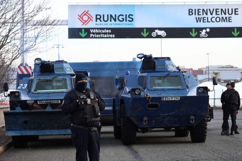 Polisi Perancis bersiaga dengan panser Berliet VXB-170 di pintu masuk Pasar Rungis, Senin (29/1/2024), di tengah unjuk rasa nasional para petani Perancis yang memprotes pembayaran, pajak, dan regulasi yang dinilai tidak mendukung pertanian. 