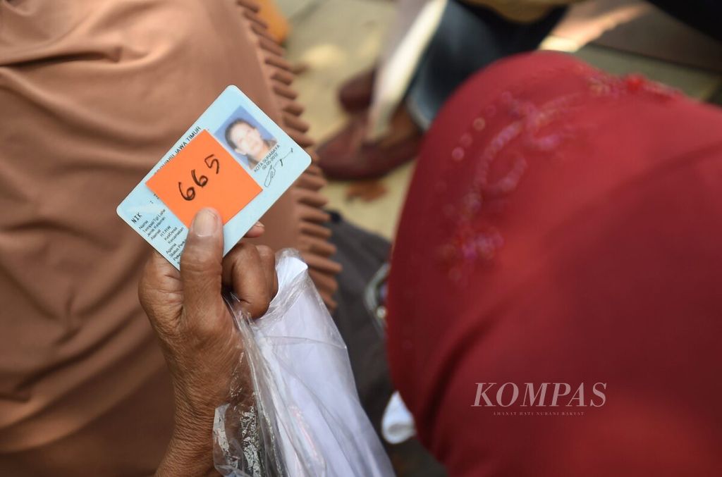 Warga yang akan mencairkan dana bantuan sosial tunai dari Kementerian Sosial menunggu di depan Kantor Pos Jalan Perak Barat, Surabaya, Jawa Timur, Selasa (12/5/2020). 