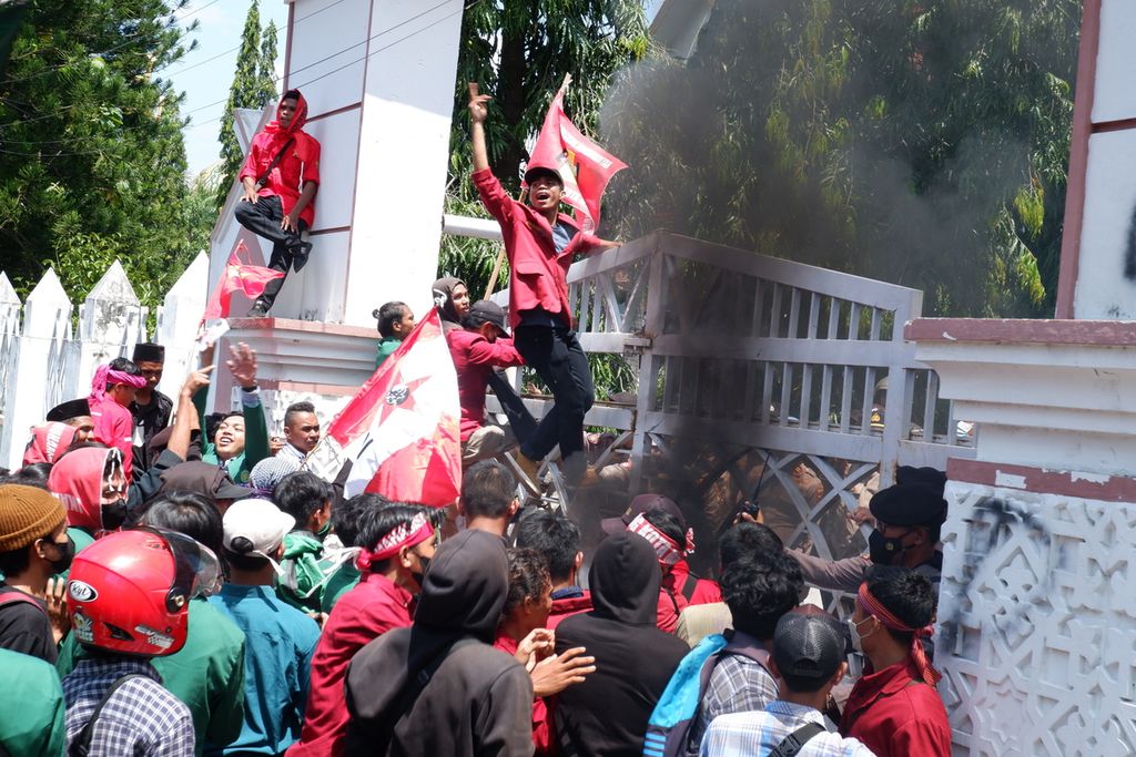 Mahasiswa menaiki pintu gerbang saat menggelar aksi di depan Kantor DPRD Provinsi NTB di Mataram, Senin (11/4/2022) siang. Dalam aksi tersebut, mereka menyampaikan berbagai tuntutan, di antaranya menolak kenaikan harga BBM dan mahalnya harga minyak goreng serta menolak wacana presiden tiga periode.