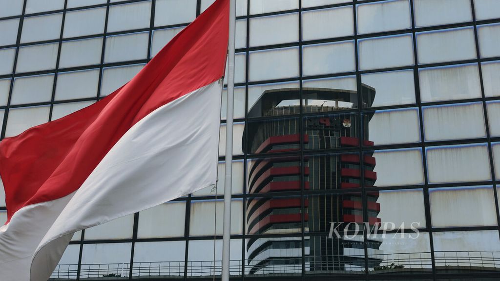 Bendera merah putih berkibar berlatar pantulan kaca Gedung Merah Putih KPK di Jakarta Selatan, Rabu (16/2/2022). 