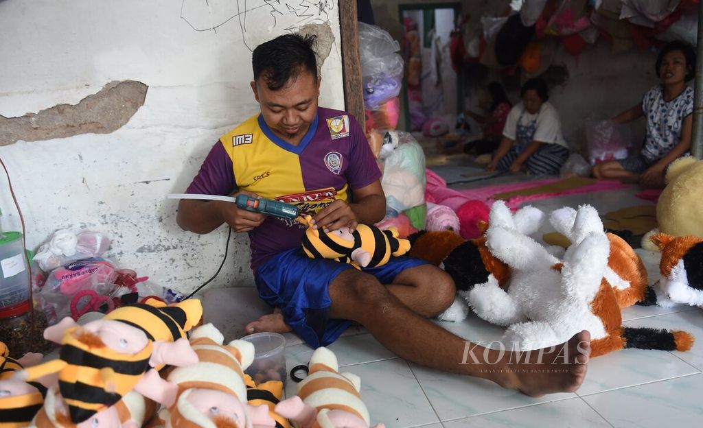 Perajin menyelesaikan pembuatan boneka lebah di Desa Sumbergedang, Kecamatan Pandaan, Kabupaten Pasuruan, Jawa Timur, Selasa (12/7/2022). Menurut pemilik usaha Abdul Kodim saat ini usaha kerajinan boneka terdampak pada kenaikan hampir di semua bahan baku. Walau demikian perajin tidak bisa menaikkan harga akibat desakan konsumen. Boneka-boneka dijual dengan Rp8.000-Rp300.000 perboneka tergantung ukuran.