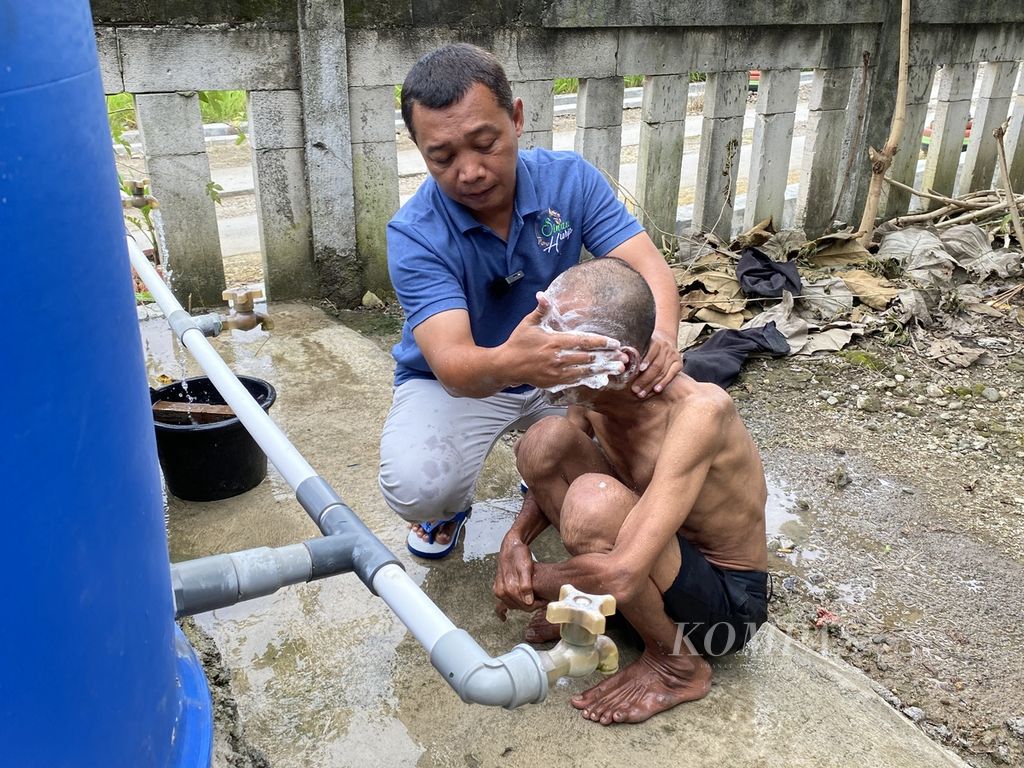 Sukaryo Adi Putra  bathes people with mental disorders in Responsharjo Village, Responsibility District, Grobogan Regency, Central Java, Saturday (5/2/2022).