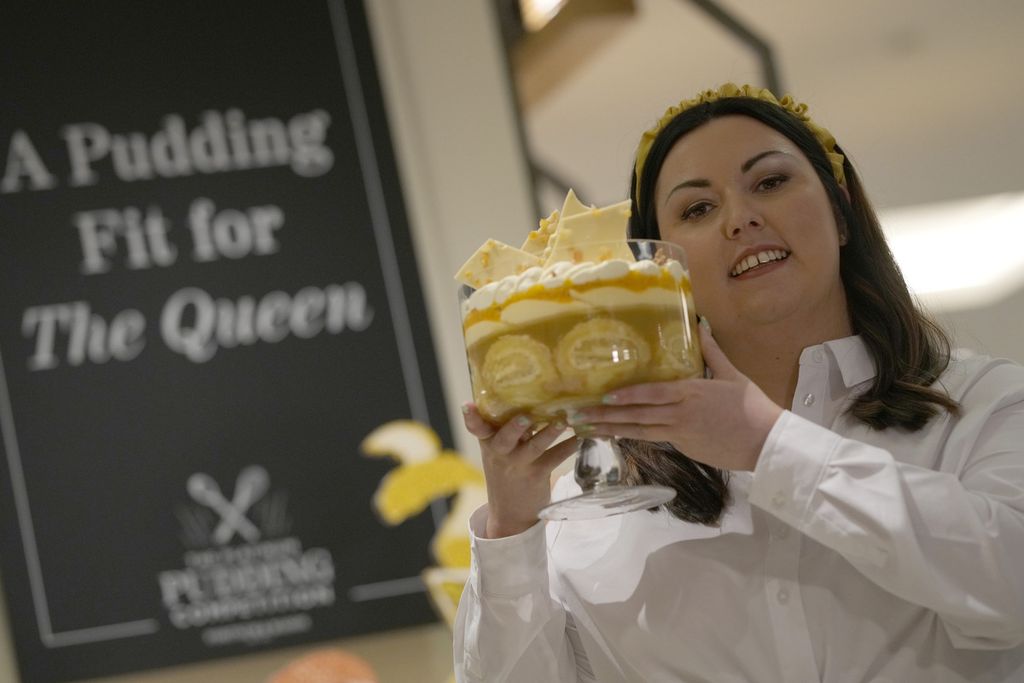 Jemma Melvin pemenang the Platinum Jubilee Pudding berpose dengan puding kreasinya di sebuah pusat perbelanjaan di London pada Jumat (13/5/2022).