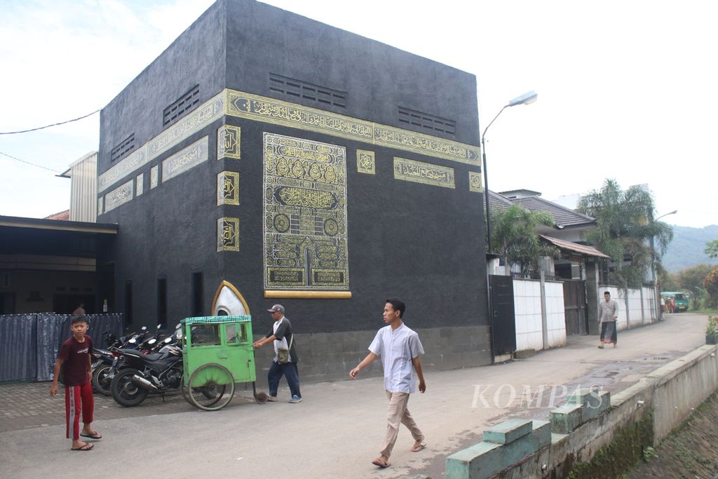 Warga melintasi Masjid Al-Majid di Kelurahan Wargamekar, Kecamatan Baleendah, Kabupaten Bandung, Jawa Barat, Jumat (1/4/2022).