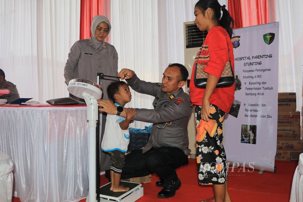Dokter kepolisian mengukur tinggi badan seorang anak yang mengalami keterlambatan pertumbuhan di Rumah Sakit Bhayangkara Medan, Sumatera Utara, Rabu (5/7/2023). Rumah sakit kepolisian ikut melaksanakan program pengentasan tengkes atau stunting di Indonesia.