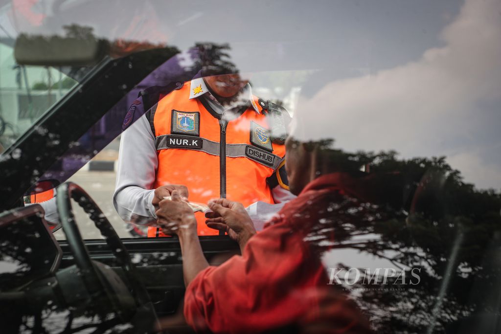 Petugas memeriksa surat kendaraan yang akan menjalani uji emisi di Jalan Perintis Kemerdekaan, Jakarta Timur, Rabu (1/11/2023). 