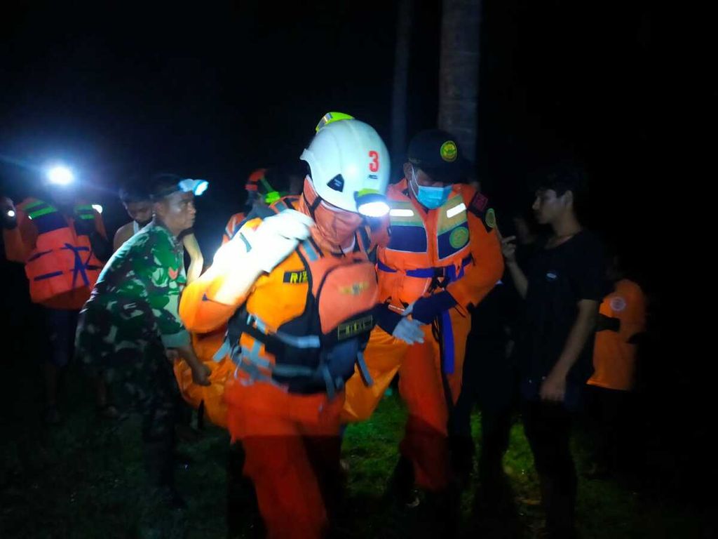Petugas mengevakuasi korban terseret air bah di Sungai Karing-karing, Bungi, Baubau, Sulawesi Tenggara, Sabtu (12/3/2022) malam. Sebanyak empat orang meninggal pada kejadian ini.