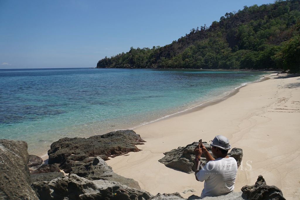 Seorang wisatawan mengambil foto, Sabtu (9/11/2019), di Pantai Pulisan, Likupang Timur, Minahasa Utara, Sulawesi Utara. Pantai ini adalah destinasi wisata utama di wilayah calon Kawasan Ekonomi Khusus (KEK) Likupang karena airnya yang jernih dan pasirnya yang putih.