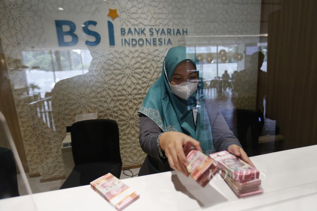 Petugas Bank Syariah Indonesia menghitung uang kertas rupiah di kantor cabang BSI Thamrin, Jakarta, Senin (22/5/2023). 