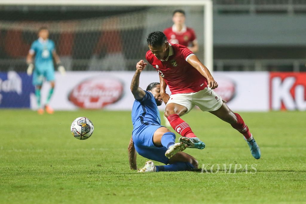 Penyerang tim nasional sepak bola Indonesia Dimas Drajad (kanan) dilanggar gelandang Curacao Shermaine Dacildes dalam laga uji coba di Stadion Pakansari, Cibinong, Bogor, Jawa Barat, Selasa (27/9/2022). Indonesia menang 2-1. 