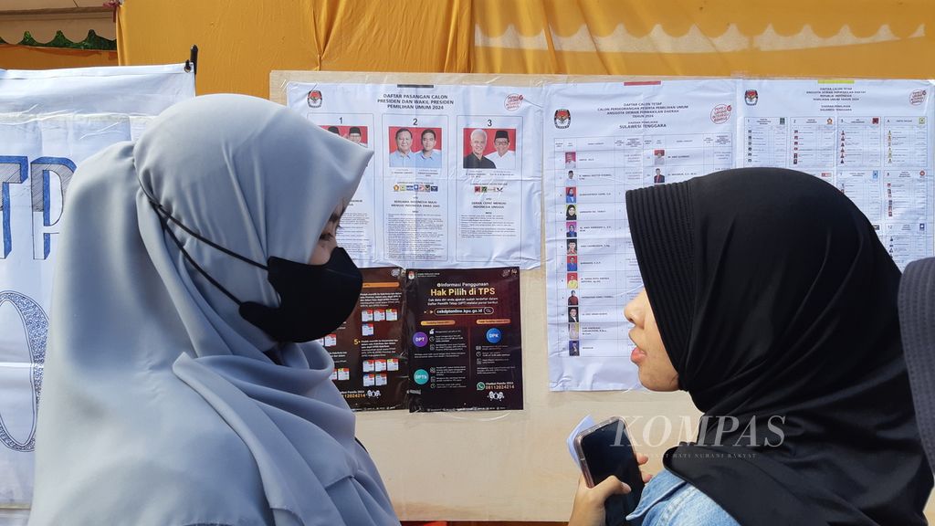 Warga mengamati daftar peserta pemilu sebelum menyalurkan hak pilih di Kendari, Sulawesi Tenggara, Rabu (14/2/2024). Warga berharap pemilu berjalan jujur, adil, dan lancar serta berujung pada perbaikan kehidupan. 