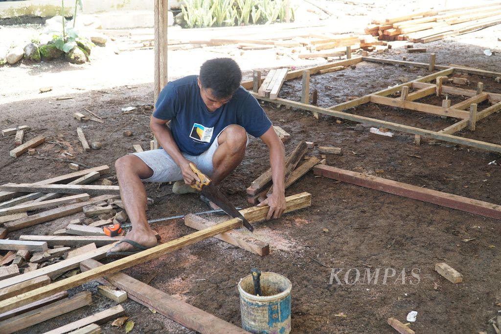 Tukang kayu mengambil kayu untuk rangka rumah hunian sementara (huntara) yang dibangun PMI Pasaman Barat bagi penyintas gempa di Jorong Tanjung Beruang, Nagari Kajai, Kecamatan Talamau, Kabupaten Pasaman Barat, Sumatera Barat, Jumat (11/3/2022). Tukang kayu memiliki padanan kata lawas <i>acawi</i>.