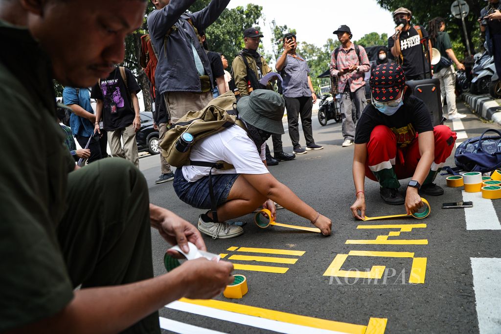 Peserta aksi membuat tulisan menggunakan lakban dalam aksi geruduk Kemenkominfo di depan kantor Kementerian Komunikasi dan Informatika, Jakarta, Rabu (10/7/2024). Aliansi Keamanan Siber untuk Rakyat mendesak Menteri Komunikasi dan Informatika Budi Arie Setiadi untuk mundur dari jabatannya karena dinilai gagal dalam mengelola keamanan data. Kasus bobolnya Pusat Data Nasional Sementera 2 (PDNS 2) telah menimbulkan kerugian materiil dan imateriil bagi warga serta menyulitkan warga mengakses layanan publik. 