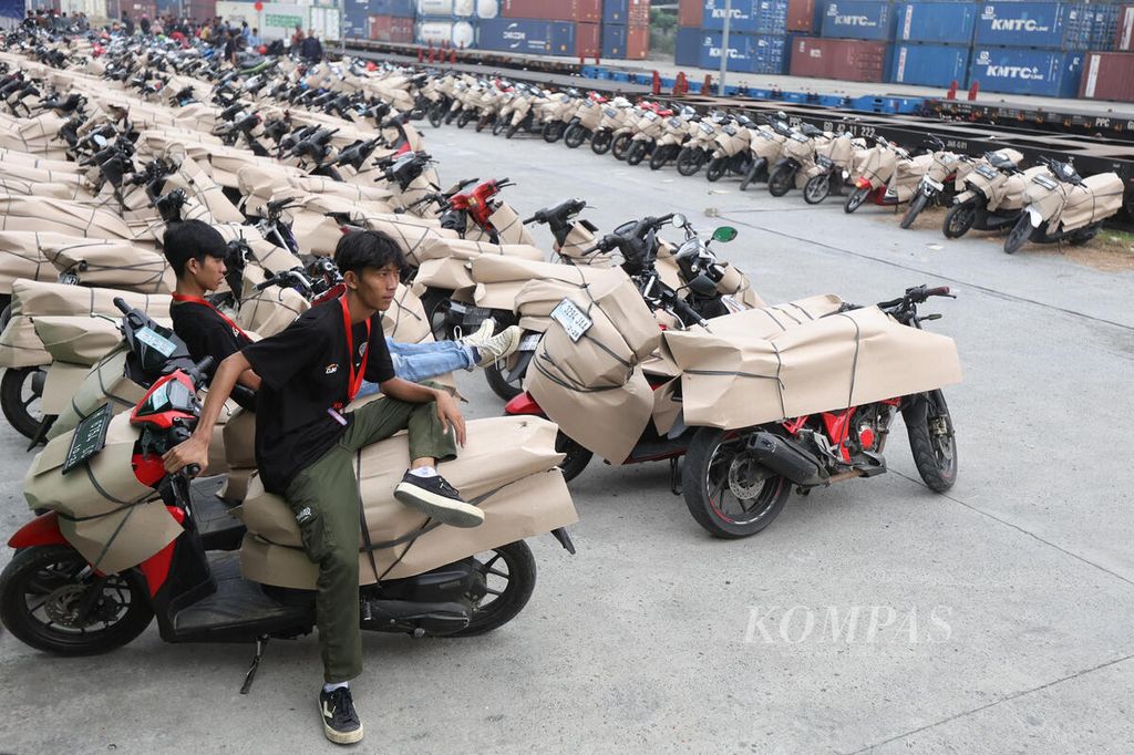 Dua petugas beristirahat di atas sepeda motor yang mengikuti mudik sepeda motor gratis di Stasiun Jakarta Gudang, Jakarta Utara, Selasa (2/4/2024). 