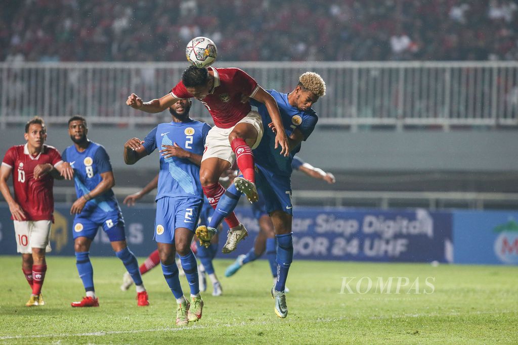 Pemain tim nasional sepak bola Indonesia Rizky Ridho Ramadhani (depan) berusaha menyundul bola saat dibayangi pemain tim Curacao Juninho Gracelio Bacuna (kanan) dalam laga uji coba di Stadion Pakansari, Cibinong, Bogor, Jawa Barat, Selasa (27/9/2022). Indonesia menang 2-1. 