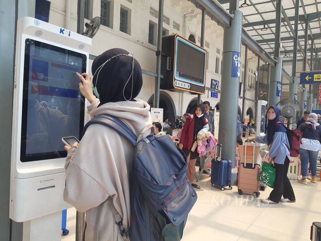 Seorang penumpang mengakses layanan untuk mencetak tiket di Stasiun Pasar Senen, Jakarta, Senin (18/12/2023). PT KAI menetapkan masa angkutan Natal dan Tahun Baru mulai 21 Desember 2023 hingga 7 Januari 2024. 