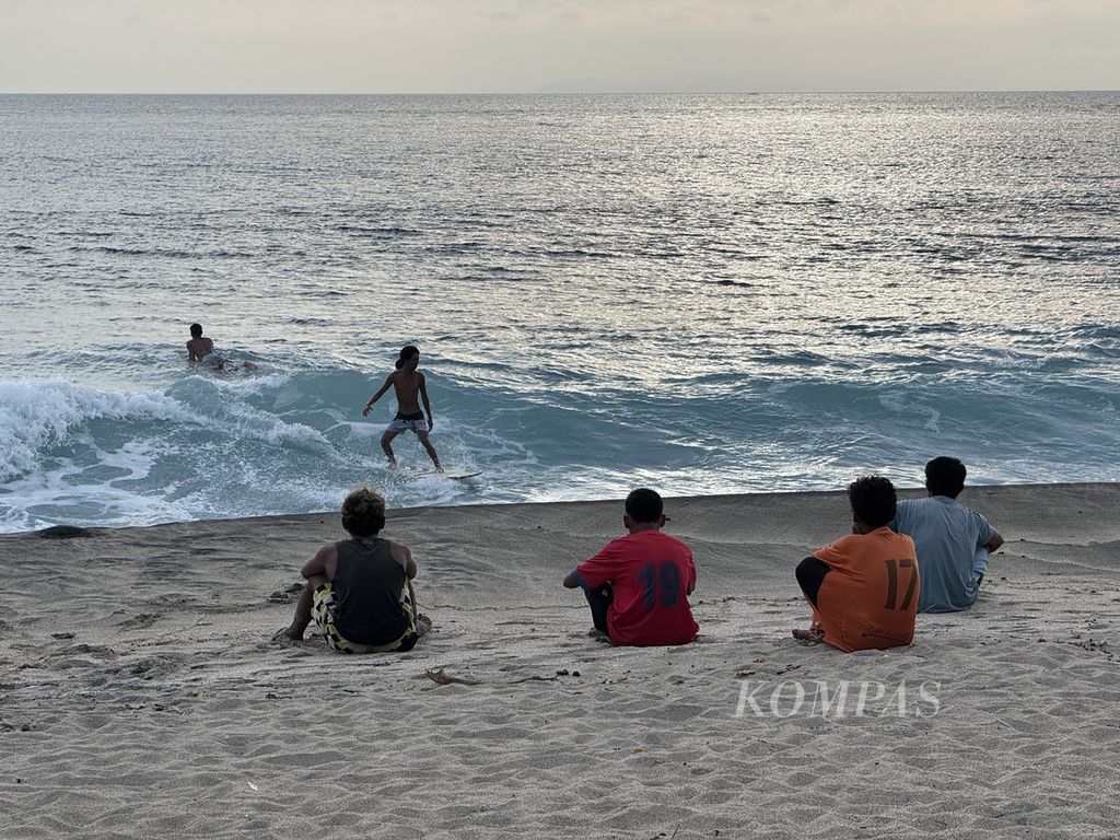 Anak-anak muda duduk di tepi Pantai Lendang Luar, Desa Malaka, Kecamatan Pemenang, Kabupaten Lombok Utara, Nusa Tenggara Barat, Rabu (6/3/2024) sore.  