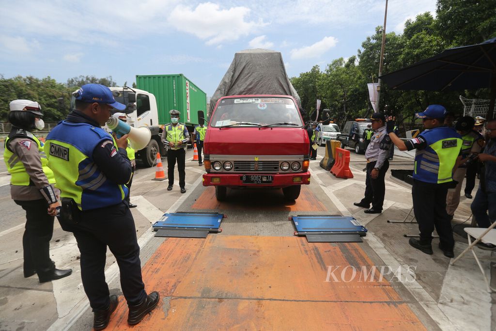 Petugas mengukur berat truk saat mengadakan razia terhadap truk angkutan di Pintu Tol Tanjung Priok 1, Koja, Jakarta Utara, Senin (9/3/2020).