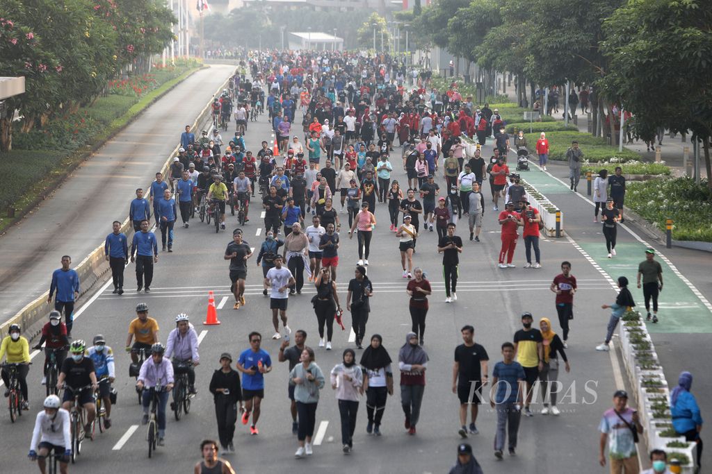 Warga berolahraga seperti bersepeda, lari, dan jalan kaki di Jalan Jenderal Sudirman, Jakarta, saat pemberlakuan hari bebas kendaraan bermotor (<i>car free day</i>), Minggu (5/6/2022). Minat warga untuk berolahraga meningkat selama masa pandemi Covid-19.