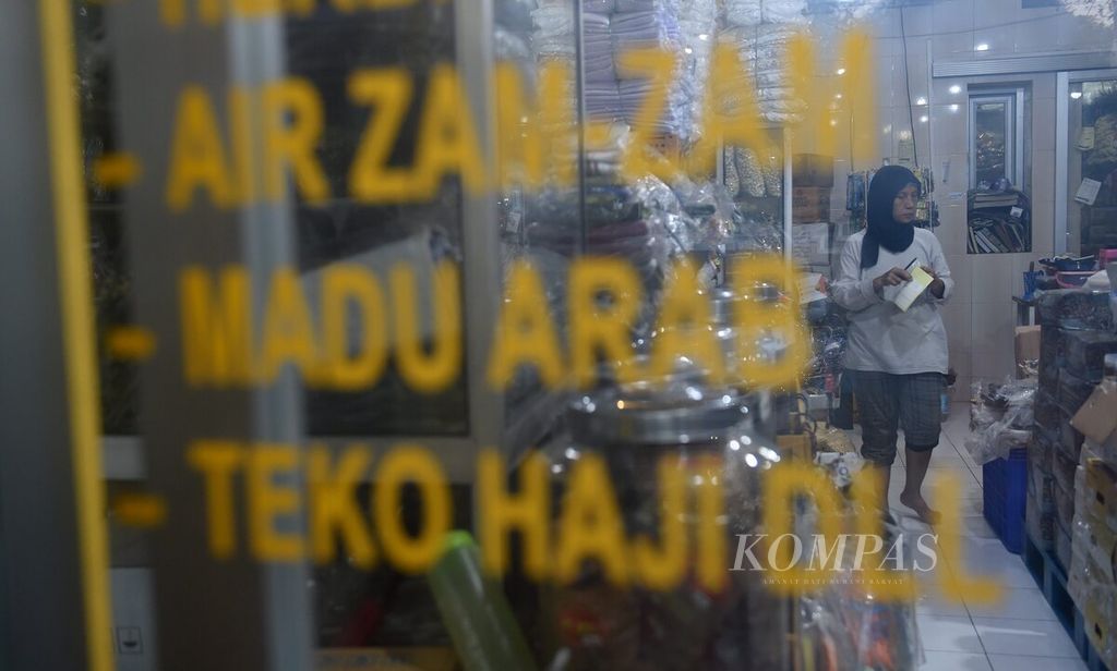 Penjaga toko oleh-oleh haji dan umroh mengecek barang di Jalan Nyamplungan, Surabaya, Jawa Timur, Selasa(18/7/2023). Saat musim haji, toko oleh-oleh tersebut banjir pembeli. Pembeli terbesar banyak datang dari Pulau Madura. 