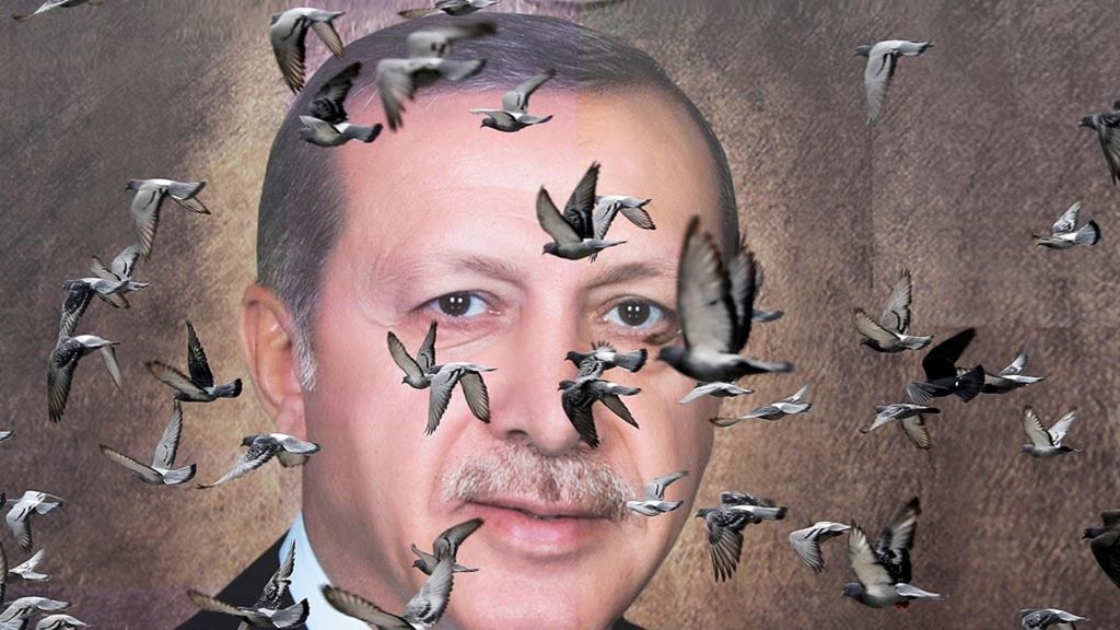 Burung-burung merpati terbang di depan poster besar bergambar Presiden Turki Recep Tayyip Erdogan di Bursa, Turki, Sabtu (6/4/2019). Kekalahan Partai Keadilan dan Pembangunan (AKP) di kota-kota besar pada pemilu lokal, 31 Maret lalu, merupakan lampu kuning bagi masa depan AKP dan Erdogan.
