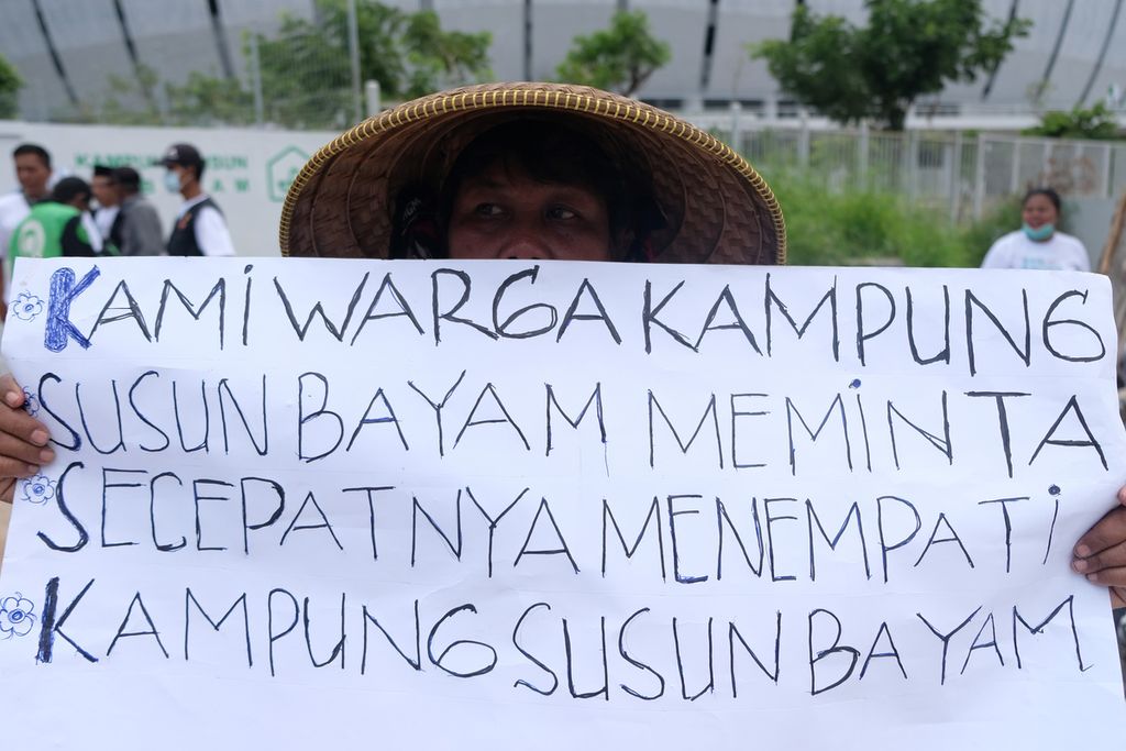 Warga membawa poster tuntutan kepada pihak PT Jakarta Propertindo (JakPro) di depan Stadion Jakarta International Stadium (JIS), Jakarta Utara, Senin (21/11/2022).