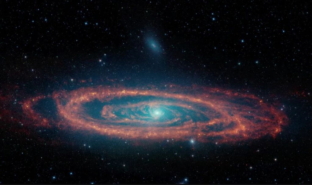Una imagen de la galaxia espiral Andrómeda procesada a partir de datos del Telescopio Espacial Spitzer.  Las imágenes tomadas en diferentes longitudes de onda muestran la distribución de estrellas, polvo y regiones de formación estelar en Andrómeda.