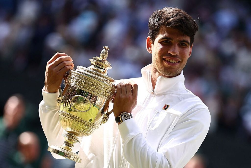 Petenis Spanyol, Carlos Alcaraz, berpose dengan trofi juara Wimbledon usai mengalahkan petenis Serbia, Novak Djokovic, di London, Inggris, Minggu (14/7/2024). 