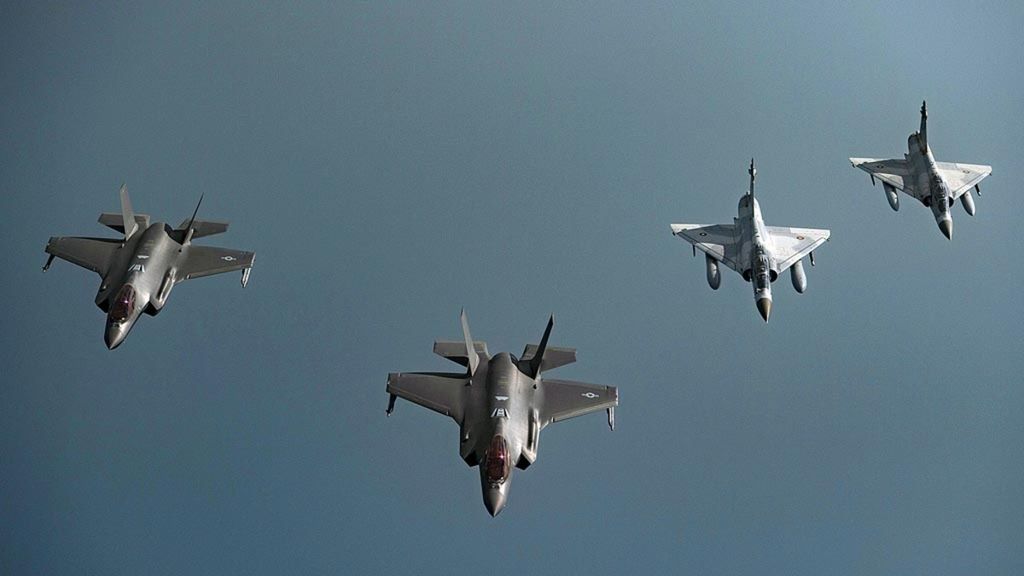 Jet tempur Mirage 2000 milik Angkatan Udara Qatar atau QEAF (kanan) dan F-35A Lightning II milik Angkatan Udara AS terbang dalam formasi di atas udara wilayah Asia Barat Daya, 21 Mei 2019. Qatar menyediakan Pangkalan Udara Al-Udeid untuk pangkalan udara militer AS.