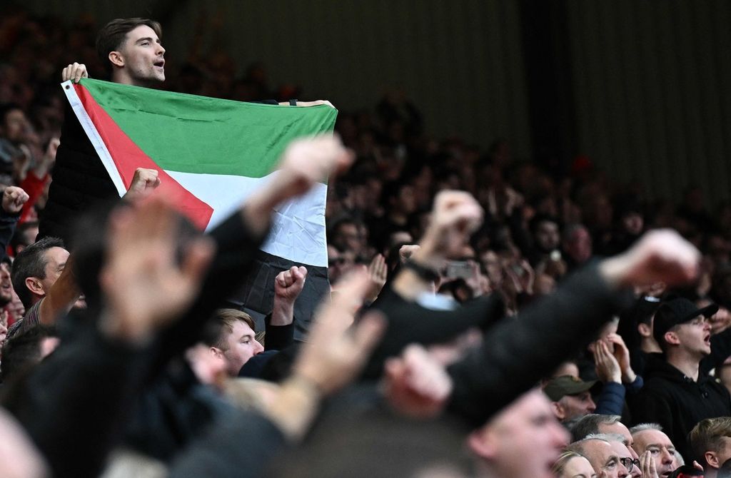 Seorang penonton membentangkan bendera Palestina saat pertandingan Liga Inggris antara Liverpool dan Everton di Stadion Anfield, Liverpool, Sabtu (21/10/2023). 