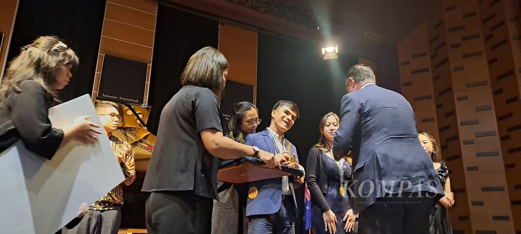 Juara I kategori Senior Profesional IIPC 2024, Michael Anthony Kwok, tengah menerima medali, piala, dan hadiah uang.