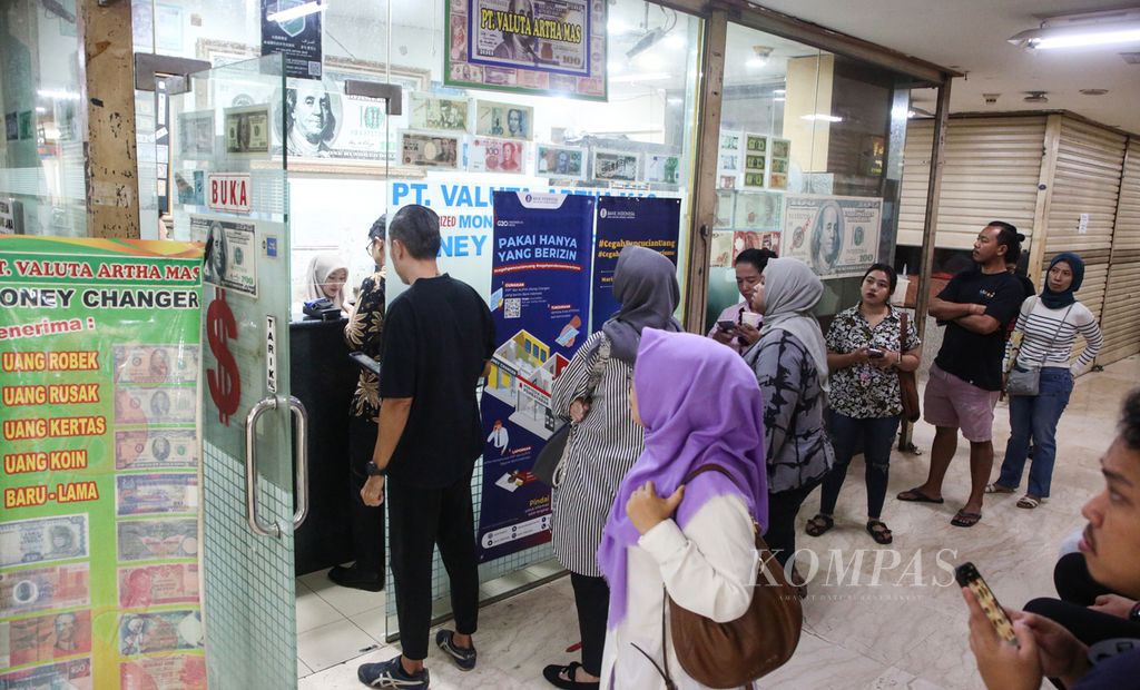 Antrean pengunjung di tempat penukaran valuta asing PT Valuta Artha Mas di Jakarta, Selasa (16/4/2024).