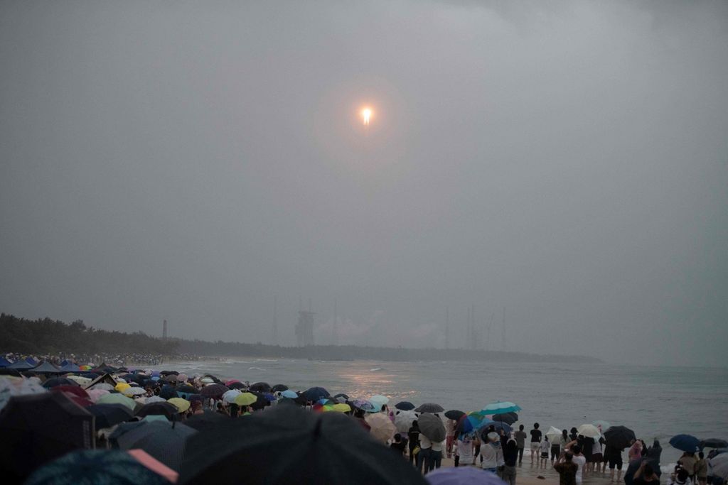 Warga menyaksikan peluncuran roket Long March 5, yang membawa wahana penjelajah Chang'e-6, di pantai dekat Pusat Peluncuran Wenchang di Provinsi Hainan, China, Jumat (3/5/2024). 